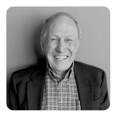 A black and white photo of an older man smiling.